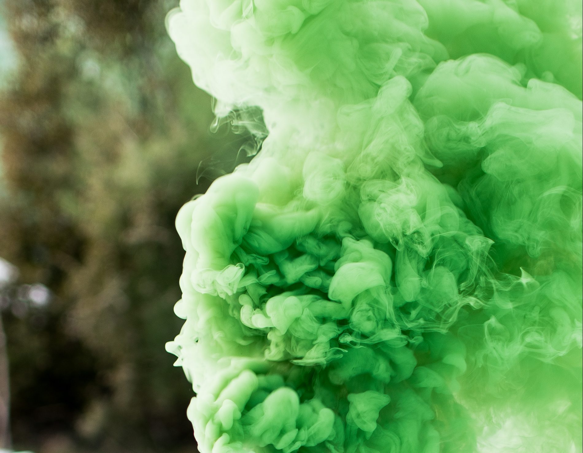 shallow focus photography of canister producing green smoke