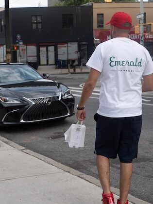 man holds bag of cannabis products and carries to car for delivery