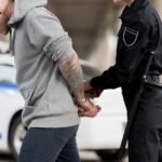 cropped shot of policewoman handcuffing young male bandit