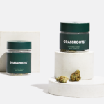 glass jar of flower with dark green label that reads grassroots