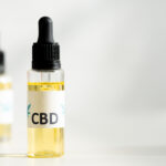 a dropper bottle labeled CBD and another behind it out of focus