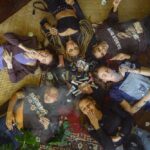 a group of women laying down on the ground in a circle smoking joints